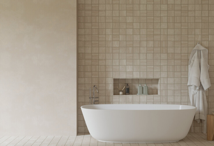 Salle de bains minimaliste avec baignoire îlot blanche en carrelage mural beige texturé.