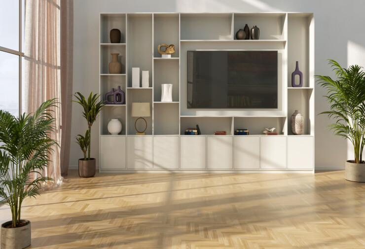 Salon lumineux avec carrelage sol intérieur imitation parquet clair en chevrons, meuble blanc et plantes décoratives.